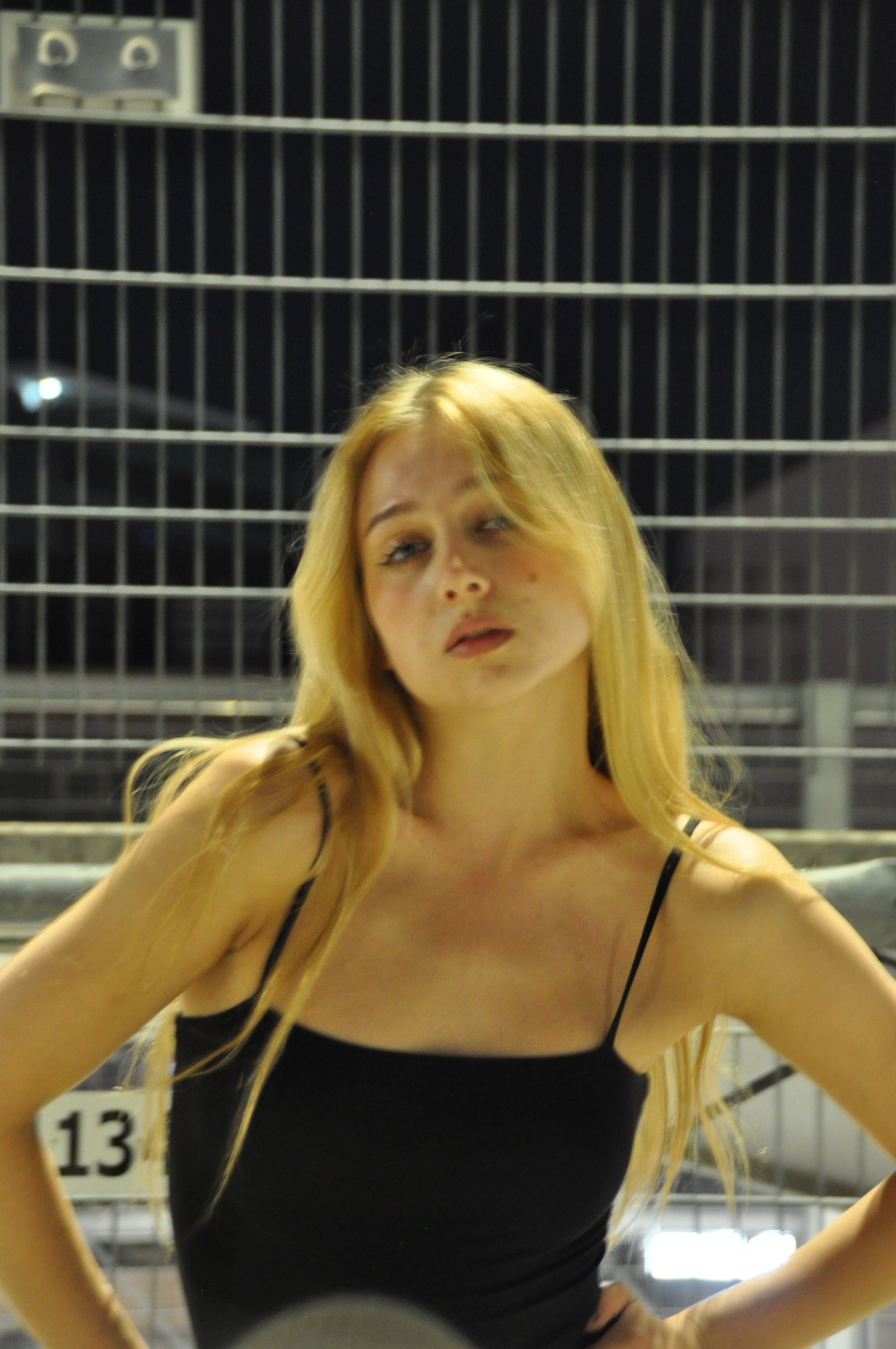 Amy Strupix bei Nacht am Zaun