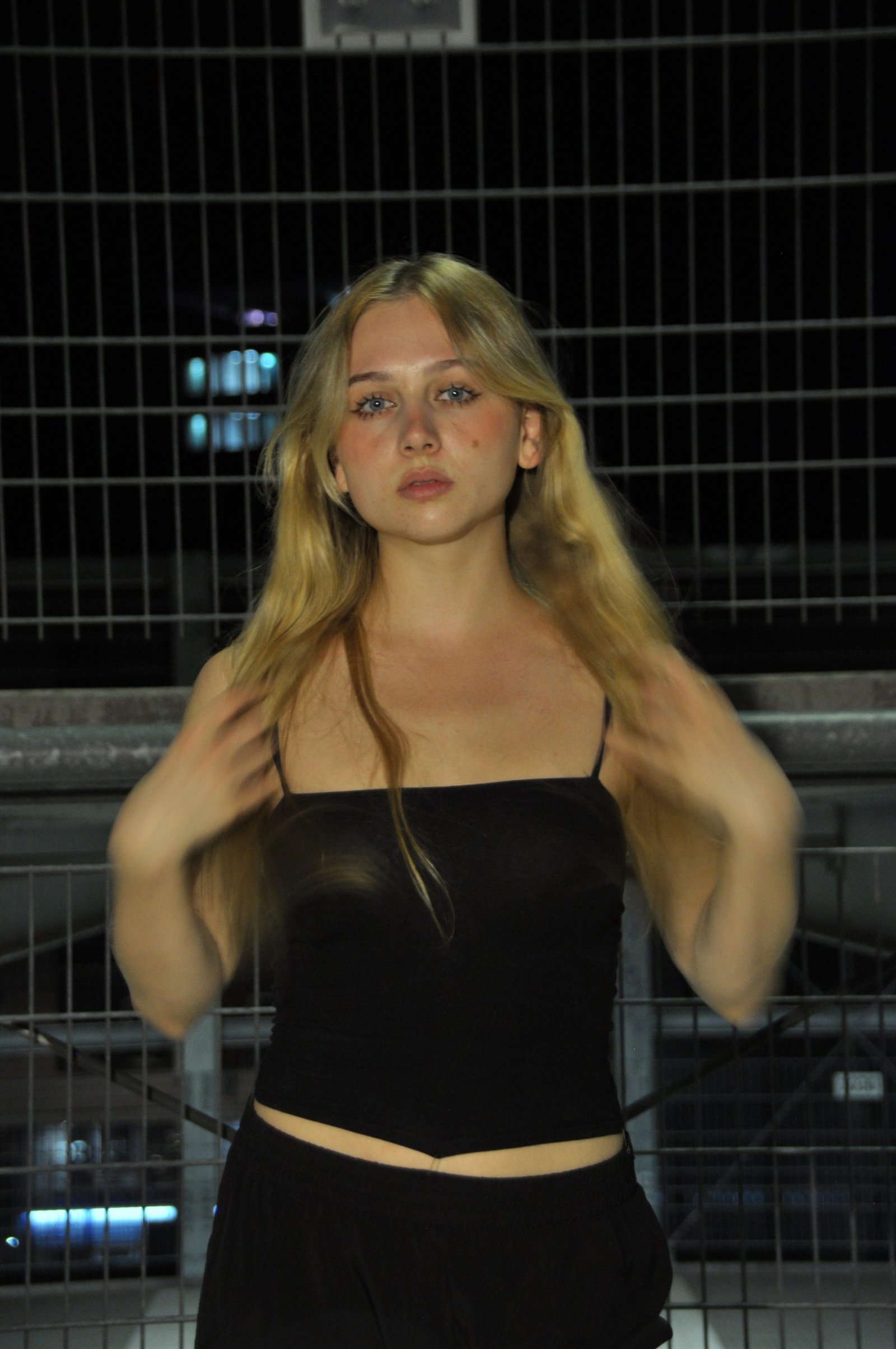 Amy Strupix bei Nacht am Zaun